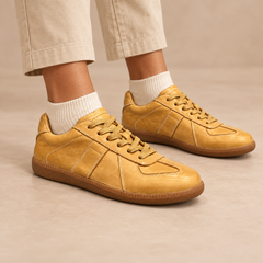 Mustard water-washed horse leather lace-up sneakers worn with beige chinos and cream socks