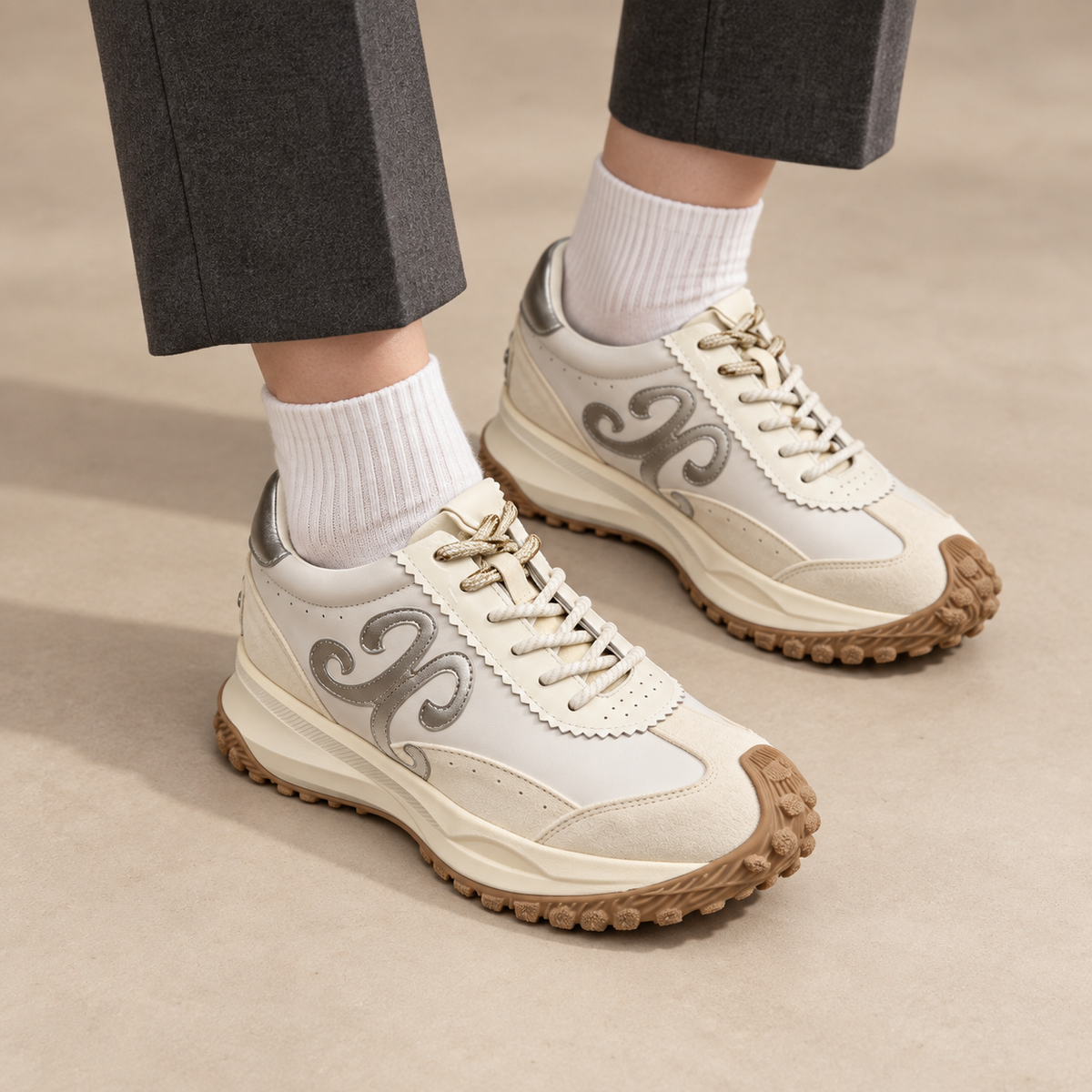Silver suede panelled lace-up sneakers worn with charcoal trousers and white socks