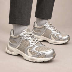 Silver panelled leather lace-up sneakers worn with charcoal trousers and gray socks