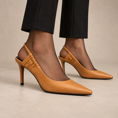 Tan gathered-strap leather slingback pumps worn with black trousers