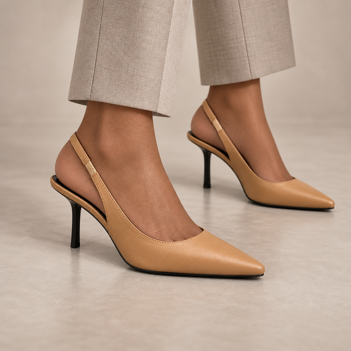 Tan pointed-toe leather slingback pumps worn with stone trousers