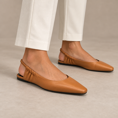 Tan square-toe gathered-strap slingback flats worn with ivory trousers