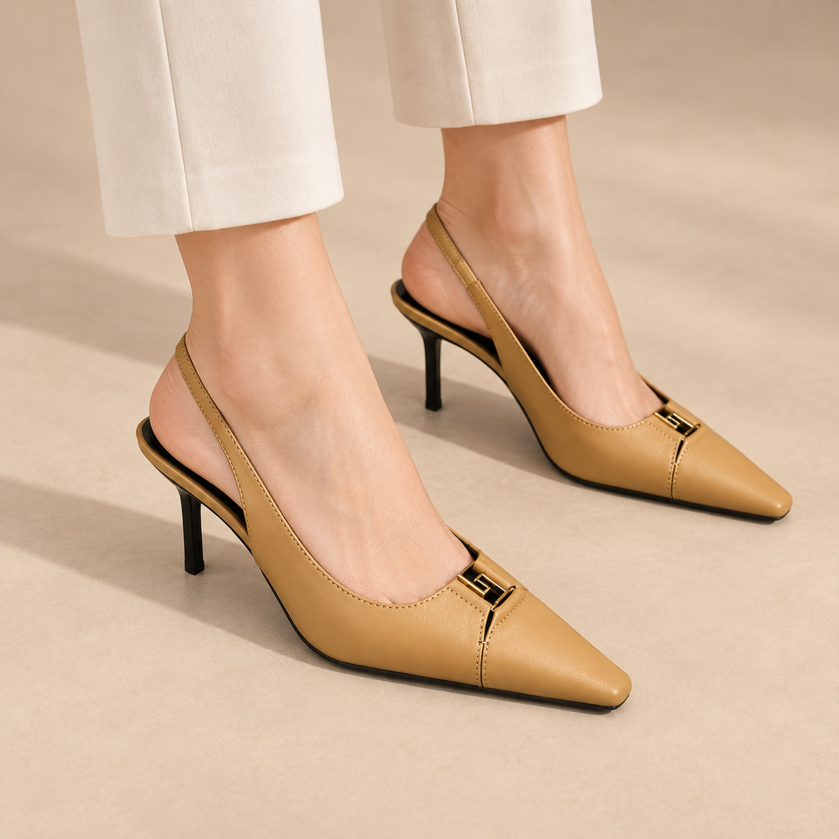 Tan square-toe metal-accent slingback pumps worn with ivory trousers
