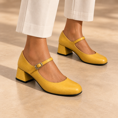 Yellow water-washed horse leather block-heel Mary Jane pumps worn with ivory trousers