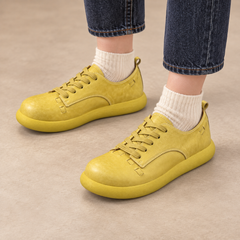 Yellow washed horse leather low-top sneakers worn with dark denim and cream socks